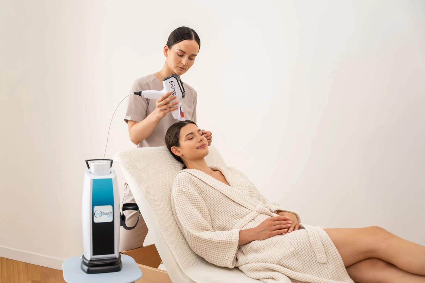 Zabieg CryoTouch MD na twarzy klientki, urządzenie obok fotela